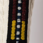 CABLE KNIT WITH JACQUARD RIBBONS AND TASSELS